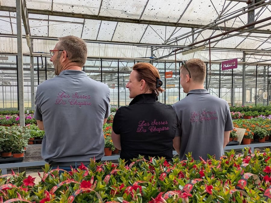 L’équipe des Serres du Chapitre échangeant au milieu des plants, sous la serre