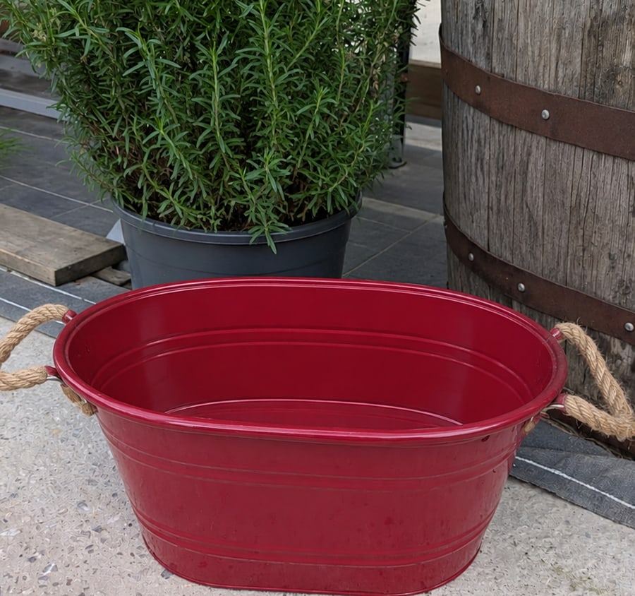 La même jardinière rouge, vide, avant le fleurissement